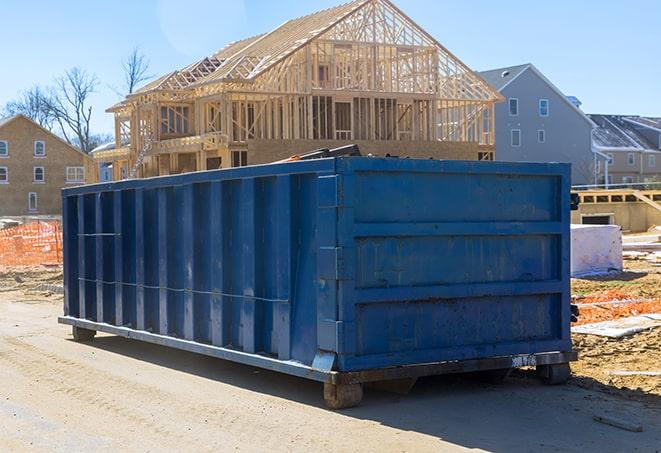 construction debris piled high in a dumpster at a job site